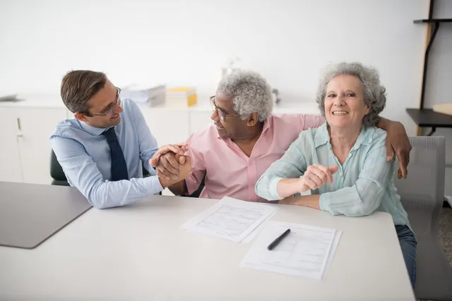 Insurance broker assisting a couple with paperwork