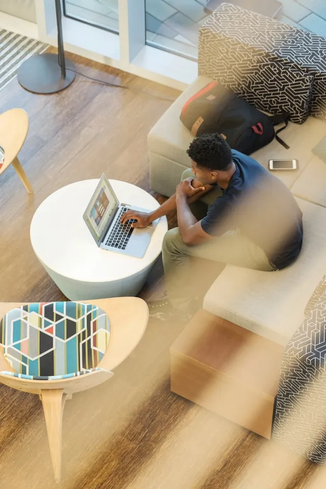 Man sitting in an armchair using a laptop