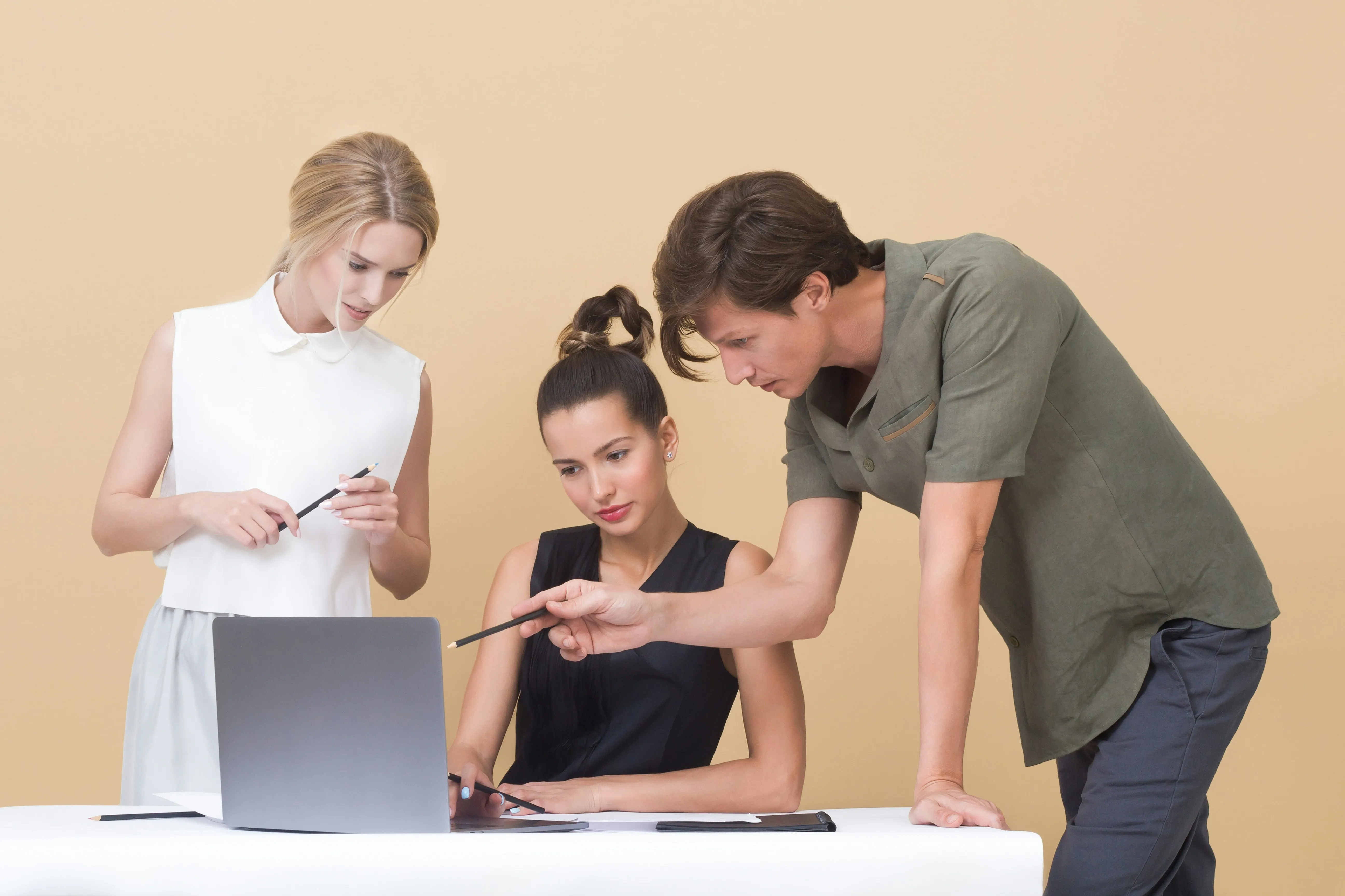 Pessoas em frente a um laptop analisando sua tela