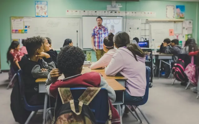 Teacher talking with students in a classroom